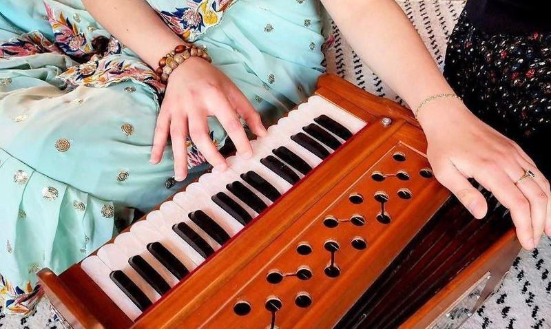 Mains sur le clavier d'un harmonium, l'instrument du kirtan